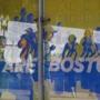 People were seen through an advertisement near the Boston Marathon finish line on Sunday as the city was awash with sunshine and determination.
