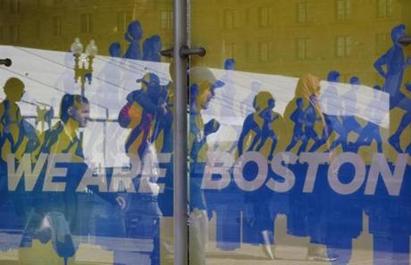 People were seen through an advertisement near the Boston Marathon finish line on Sunday as the city was awash with sunshine and determination.
