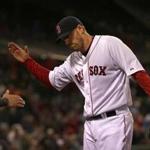 Boston Red Sox starting pitcher John Lackey gets a hand as he enters the Sox dugout after eight strong innings. 