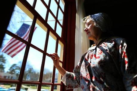 Guide Kathy Eastman looks out a window at Buckman Tavern, where Lexington’s militiamen awaited the British in 1775.
