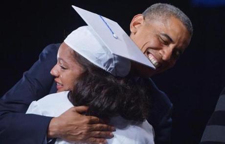The president hugged a student as she received her diploma.
