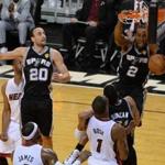 Spurs forward Kawhi Leonard dunked while being defended by the Heat?s Chris Bosh.
