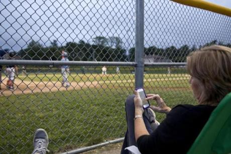 Patty Andresino caught up on her Facebook page while her son, Joe, played for Sullivan Insurance in the Milton Little League playoffs.
