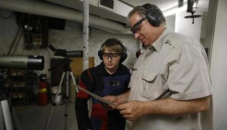 Rio Ferguson, 10, looked over his score with his dad after he finished target shooting.
