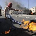 A Palestinian kicked a tire after setting it ablaze during clashes with Israeli police in a Jerusalem suburb on Wednesday. 