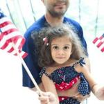 Camila Colón settled into the arms of her father, Michael, and waited as her mother, Yuderca, became a US citizen.