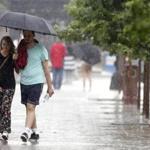 Pedestrians walked in the rain in Boston as the effects of Hurricane Arthur were felt in the area on July 4.