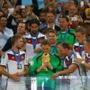 Keeper Manuel Neuer of Germany kisses the World Cup trophy with teammates after defeating Argentina 1-0 in extra time. 