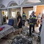 Emergency workers and Israeli security check a house damaged by a rocket fired in Ashkelon on Wednesday.