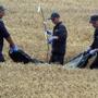 Workers collected bodies of victims from the Malaysia Airlines explosion and crash on Saturday near Grabove, Ukraine.
