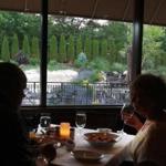 Diners inside Rosaria Steakhouse in Saugus look out at the patio and rock garden.