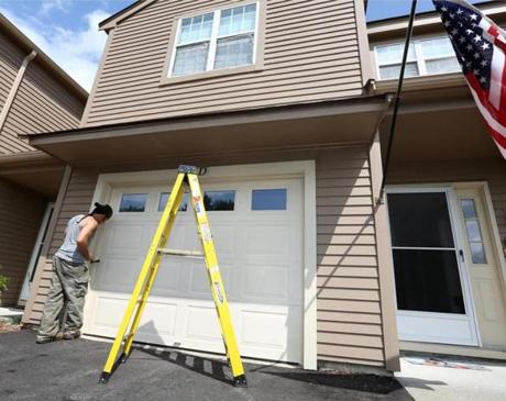 Jim and Teresa Anapol left a four-bedroom house in Stow for the convenience of a condo, here getting a new garage door.
