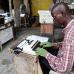 A typist at work in Monrovia, Liberia, used gloves as a protective measure to avoid the deadly Ebola virus.