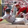 Daniel Nava slides home with a first-inning run, eluding the tag of  Reds catcher Devin Mesoraco. AP Photo/David Kohl