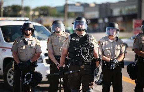 Officers watched demonstrators in Ferguson.
