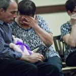 Patty Martel (center) wiped tears from her eyes as she and her husband, Brian Martel (left), mourned their daughter during Friday?s memorial service.