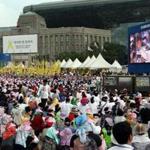 Pope Francis was displayed on a screen as a crowd gathered in Seoul Plaza to watch the beatification ceremony.