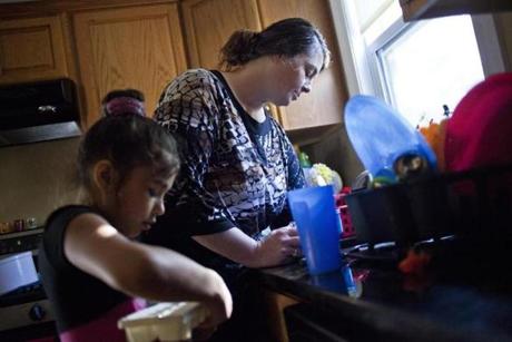 Michelle Chaudhry prepares dinner with her daughter Nadia, 9, earlier this summer in their shelter housing in Hyde Park.  She recently enrolled in a free 11-week college prep class.
