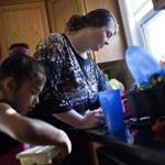 Michelle Chaudhry prepares dinner with her daughter Nadia, 9, earlier this summer in their shelter housing in Hyde Park.  She recently enrolled in a free 11-week college prep class.
