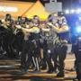 Law enforcement officers moved in formation during a protest on West Florissant Avenue in Ferguson, Missouri Monday night.