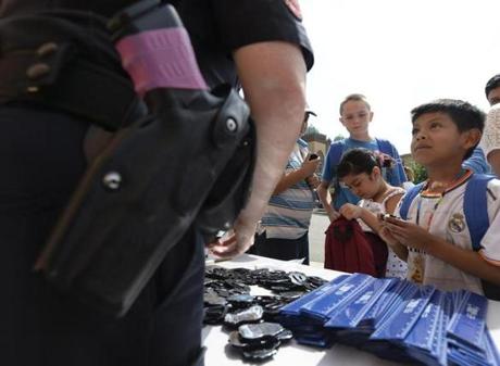 Jose Ramirez, 6, of Chelsea looked up at a police officer at the back-to-school celebration at Williams School.
