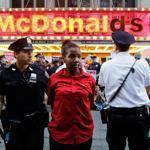 Police officers arrested a protester in front of a McDonald?s restaurant in New York?s Times Square on Thursday.