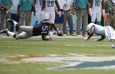 Patriots outside linebacker Jerod Mayo stretched to recover a ball fumbled by Miami.
