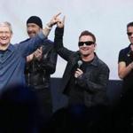 Apple chief executive Tim Cook (left) greeted the crowd with U2?s The Edge (second from left) and Bono at Tuesday?s event. U2 announced that its new album, ?Songs of Innocence,? is now available exclusively on iTunes for free until Oct.13. (Photo by Justin Sullivan/Getty Images)