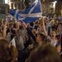 Supporters of the Yes campaign in the Scottish independence referendum cheer with Scottish Saltire flags as they await the result after the polls closed.