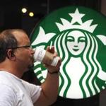 A man drinks a Starbucks coffee