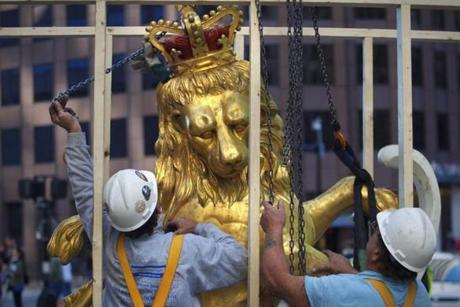 An iconic statue of a lion atop the Old State House on Washington Street in Boston was hoisted down from its rooftop perch for restoration. 
