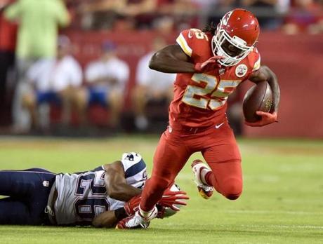 KANSAS CITY, MO - SEPTEMBER 29: Jamaal Charles #25 of the Kansas City Chiefs is tripped up by Logan Ryan #26 of the New England Patriots during the first quarter at Arrowhead Stadium on September 29, 2014 in Kansas City, Missouri. (Photo by Peter Aiken/Getty Images)

