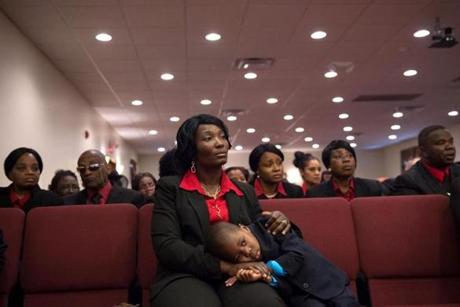 Lynda Williams listened to Rhode Island state health director Dr. Michael Fine address the congregation at the Christ Center of Praise in Providence. The pastor's son Joshua Cooper, 3, rested his head on her lap.
