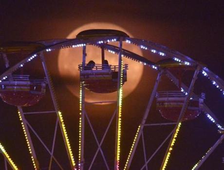 A full moon silhouettes riders at the 61st Annual Alabama National Fair in Montgomery on, Oct. 8.
