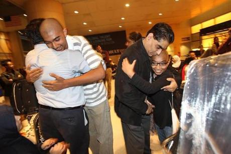 Boston, MA., 10/13/14, Brothers Ahmed and Ali, facing camera, from Wyndam, NH, were on the plane from Dubai, and are welcomed by relatives. Hazmat response to an Emirates airplane from Dubai had the anxious family members waiting for word on their loved ones. They finally reunited. Suzanne Kreiter/Globe staff (The Boston Globe.
