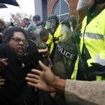 Activist Cornel West was knocked over during a scuffle with police during a protest at the Police Department in Ferguson, Mo., on Monday. REUTERS/Jim Young 