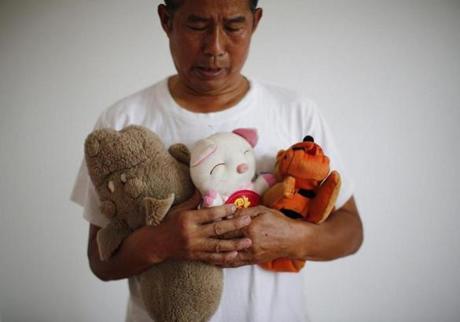 Zhang Yongli, whose daughter Zhang Qi was onboard Malaysian Airlines Flight MH370 looks at his daughter?s plush toys as he poses for a picture on July 22.
