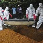 A team in protective gear buried a woman suspected of having died from Ebola in Monrovia, Liberia, on Saturday. More than 2,000 people have died from Ebola in Liberia.