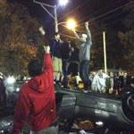Light from a circling helicopter illuminated a group of young men jumping atop an overturned car in Keene on Saturday. The city?s Pumpkin Festival goes back to 1991, but some wonder whether it has grown too big to continue. 