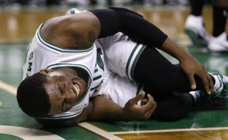 Celtics guard Marcus Smart grabs his left leg after his drive to the basket in the fourth quarter. Smart was taken from the court on a stretcher. (AP Photo/Charles Krupa)
