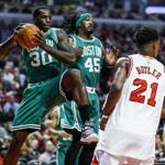Celtics forward Brandon Bass (left) grabs a rebound in front of teammate Gerald Wallace and Chicago?s Jimmy Butler in the first half Saturday. (Tannen Maury/EPA)