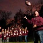Northbridge High School coach Ken LaChapelle, foreground, stands with members of his family who are or have been in his football program; his children and grandchildren have played, coached, cheered, and fetched water. 