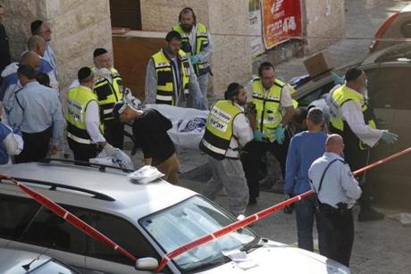 Israeli emergency services volunteers carry the body of a Palestinian assailant who was shot dead while attacking a synagogue in the ultra-Orthodox Har Nof neighbourhood in Jerusalem.
