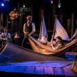 With makeshift boat are (from left) Matt Nuernberger, Ryan Melia and Curtis Gillen in the PigPen Theatre Co.  show.