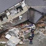An aerial view shows rescue workers investigating at collapsed houses after an earthquake in Hakuba town.