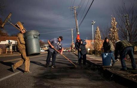 Volunteers and workers cleared soot from the site where a police vehicle was set ablaze in Ferguson.
