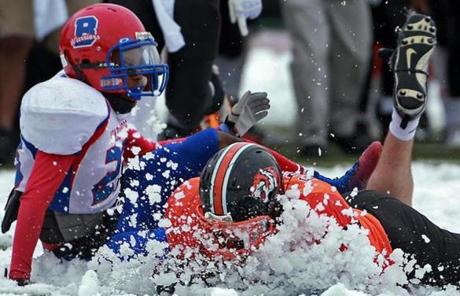 
Newton North running back Mike Gately gets a face full of snow as he was brought down by Brookline?s Tylen Rose.

