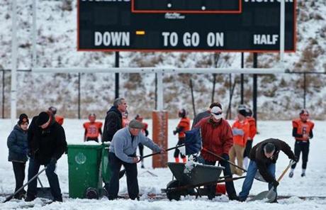 
Volunteers work to clear the field of snow at Newton North High School.

