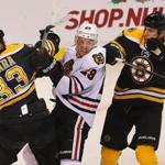 Zdeno Chara and Milan Lucic sandwiched Chicago's Bryan Bickell in the first period. 