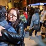 Esperanza  Espinola, an immigrant from the Philippines, was reunited with her sibling Leonila Bides, with a big hug after more than 14 years of separation.  The Logan Airport family reunion in Boston included Ezra Bides (above right), 24,  and (below). 